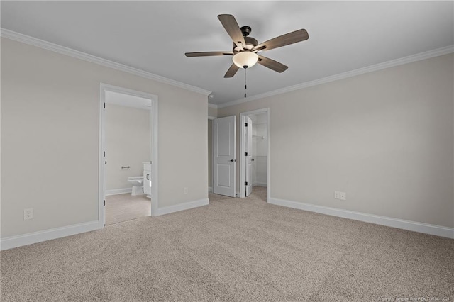 unfurnished bedroom featuring ensuite bath, ceiling fan, a spacious closet, crown molding, and light colored carpet