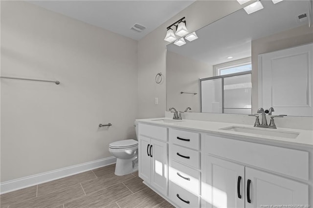 bathroom with vanity, toilet, and a shower with shower door