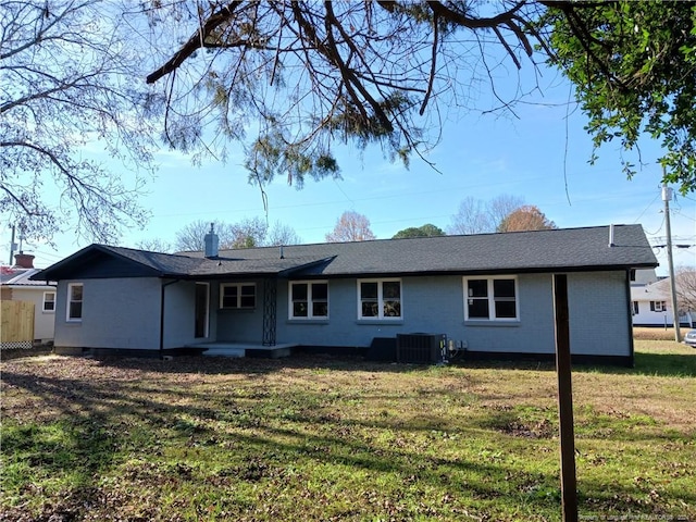 rear view of house with a yard and central AC