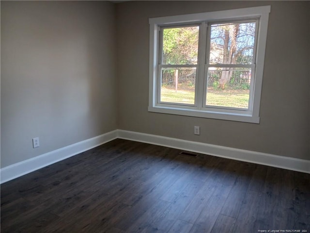 empty room with dark hardwood / wood-style flooring