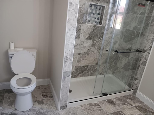 bathroom with toilet and a shower with door