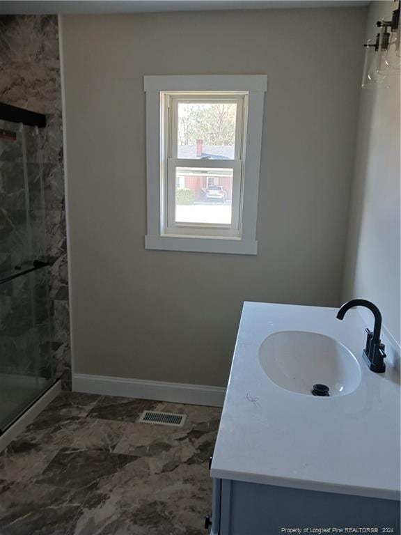 bathroom featuring vanity and an enclosed shower