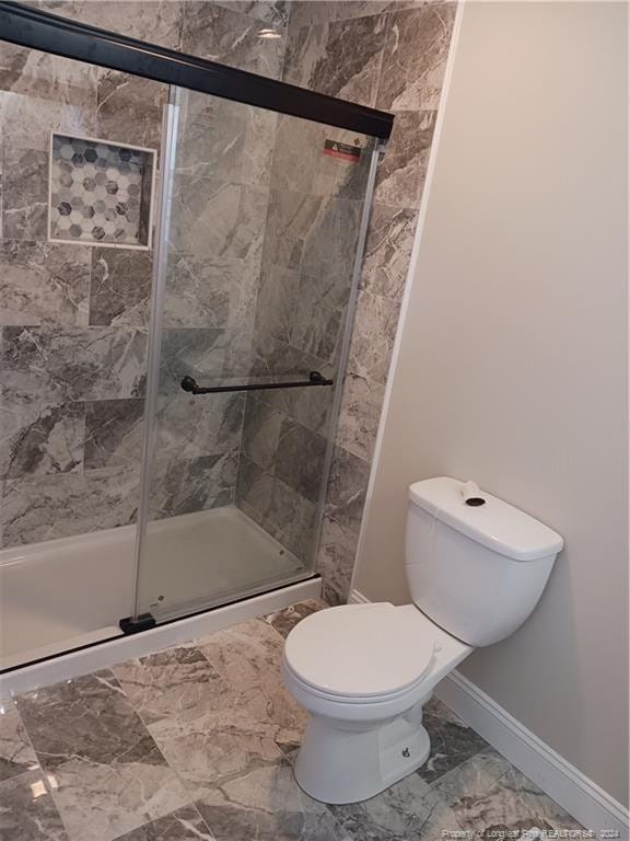 bathroom with toilet and a shower with shower door