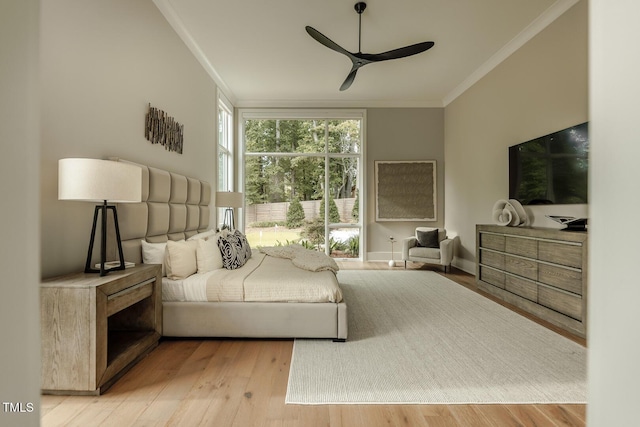 bedroom with ceiling fan, ornamental molding, and light wood-type flooring