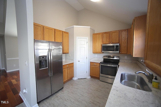 kitchen featuring sink, vaulted ceiling, and stainless steel appliances