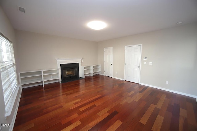 unfurnished living room with dark wood-type flooring