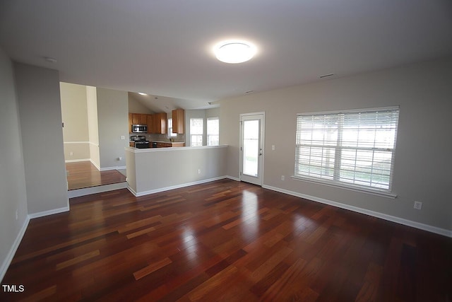 unfurnished living room featuring lofted ceiling and dark hardwood / wood-style floors