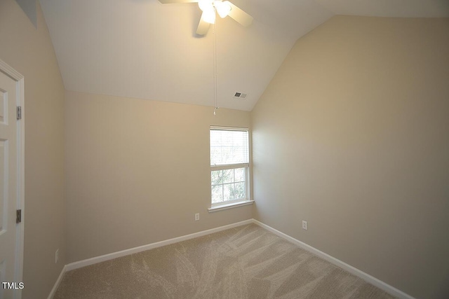 carpeted empty room featuring vaulted ceiling and ceiling fan