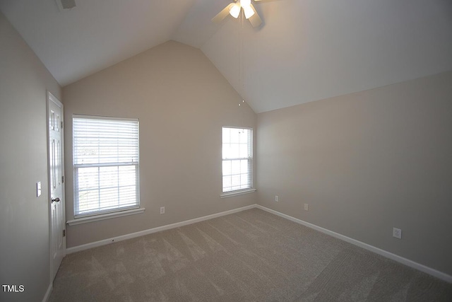 carpeted spare room featuring lofted ceiling, a healthy amount of sunlight, and ceiling fan