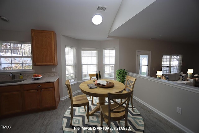 dining area featuring sink and vaulted ceiling