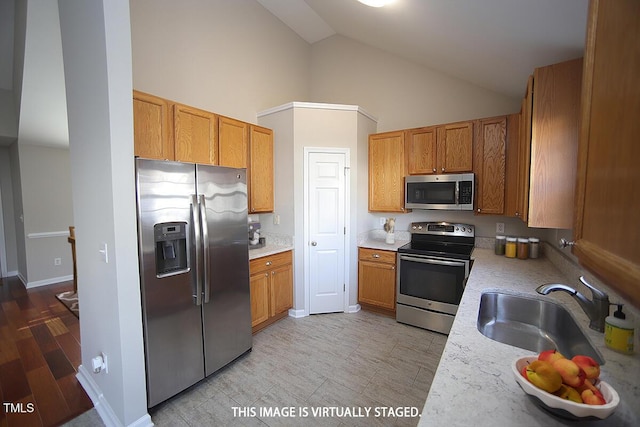 kitchen featuring high vaulted ceiling, appliances with stainless steel finishes, and sink