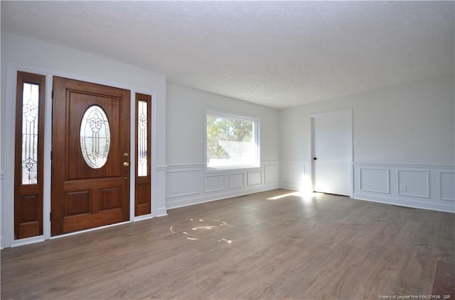 entrance foyer with dark wood-type flooring and a textured ceiling