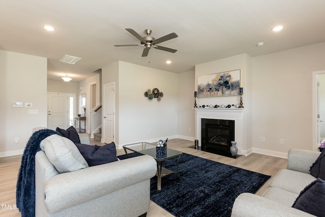 living room featuring light hardwood / wood-style floors and ceiling fan