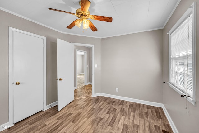 unfurnished bedroom with light hardwood / wood-style flooring, ceiling fan, and ornamental molding