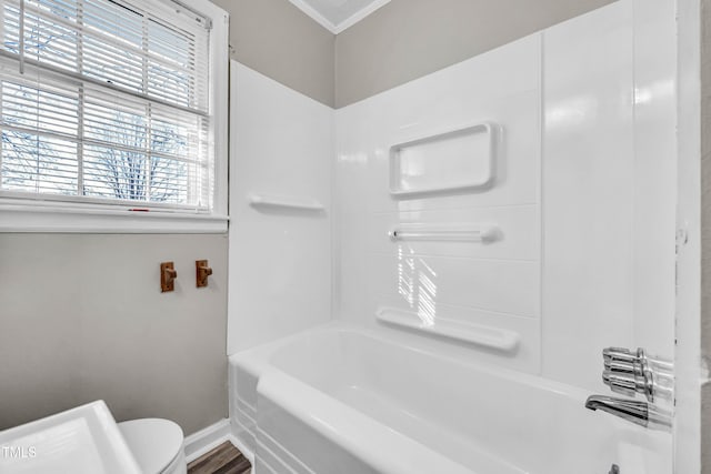 bathroom with shower / tub combination, hardwood / wood-style flooring, toilet, and a wealth of natural light