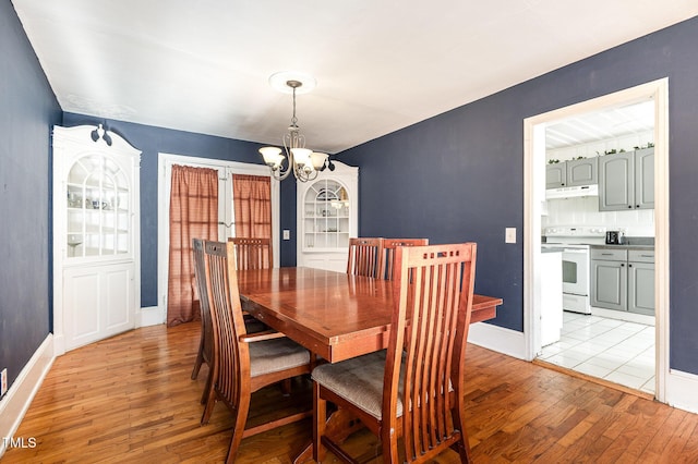 dining area featuring light hardwood / wood-style floors and a notable chandelier