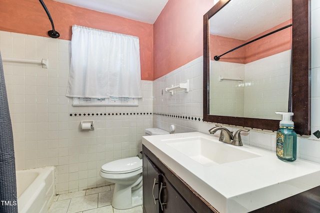 full bathroom featuring toilet, vanity, tile patterned floors, and tile walls