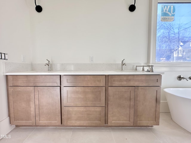 bathroom featuring a tub to relax in, vanity, and tile patterned flooring