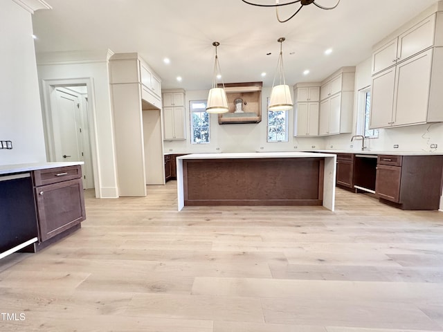 kitchen featuring light hardwood / wood-style floors, dishwasher, hanging light fixtures, crown molding, and a center island