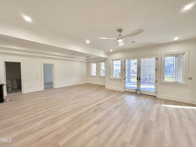 unfurnished living room featuring ceiling fan, a wealth of natural light, crown molding, and light hardwood / wood-style flooring