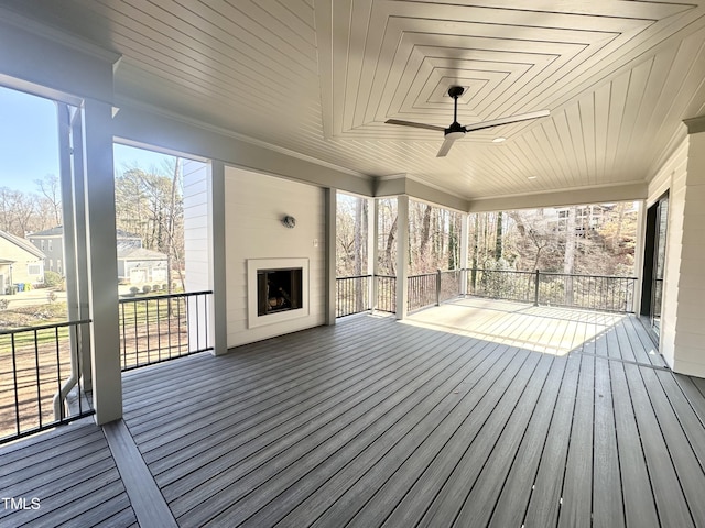 deck featuring ceiling fan and a fireplace