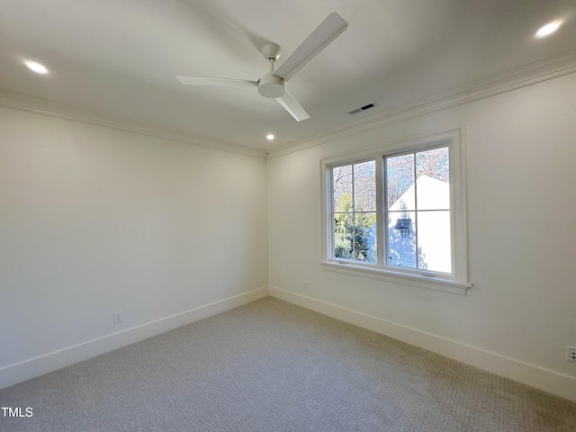 carpeted spare room featuring ceiling fan and crown molding