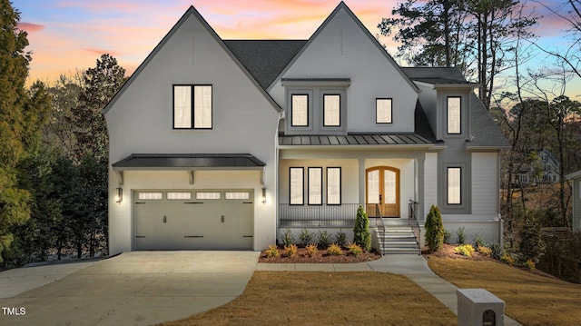 modern inspired farmhouse featuring metal roof, an attached garage, brick siding, concrete driveway, and a standing seam roof