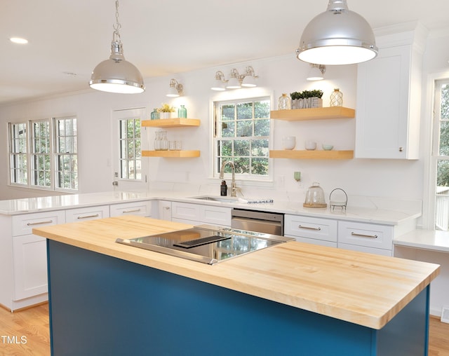 kitchen with white cabinets, a center island, butcher block countertops, and pendant lighting