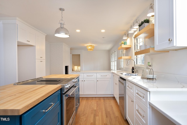 kitchen with blue cabinetry, white cabinetry, sink, and stainless steel appliances