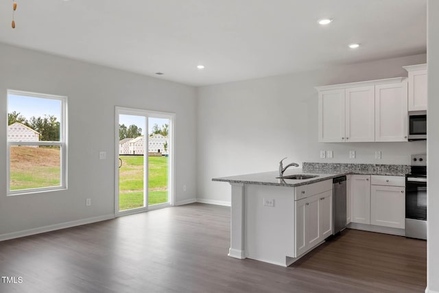 kitchen featuring kitchen peninsula, appliances with stainless steel finishes, and white cabinetry