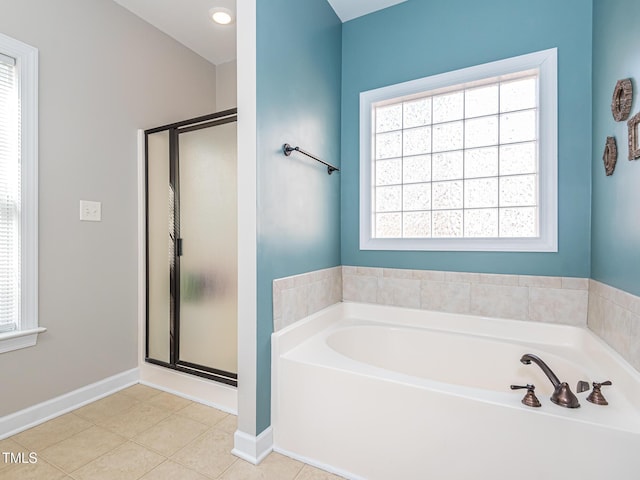 bathroom featuring a garden tub, baseboards, a shower stall, and tile patterned floors