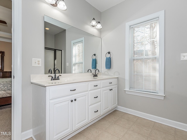 full bathroom with ensuite bathroom, a sink, a wealth of natural light, and baseboards