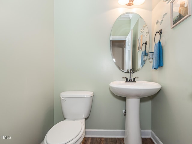 bathroom with wood finished floors, toilet, and baseboards