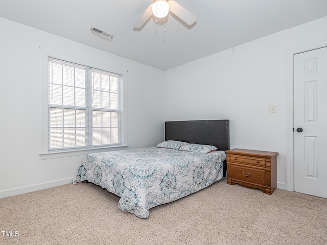 bedroom featuring baseboards, ceiling fan, visible vents, and light colored carpet