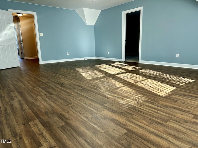 additional living space featuring baseboards, vaulted ceiling, and dark wood-style flooring