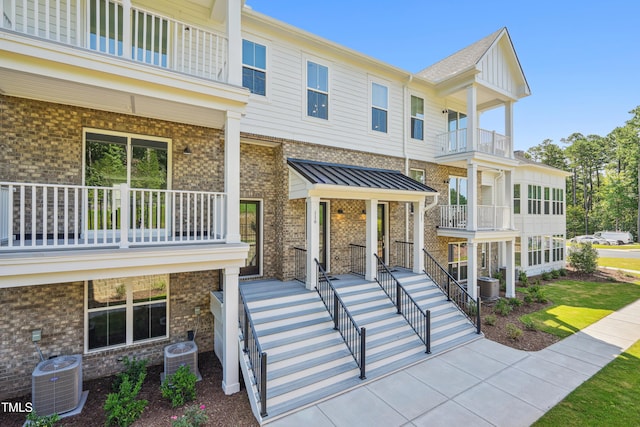 view of front facade with a balcony, covered porch, and central AC unit