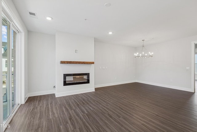 unfurnished living room featuring dark hardwood / wood-style flooring and a notable chandelier