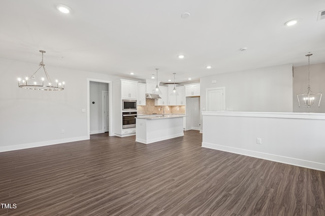 unfurnished living room featuring an inviting chandelier, dark hardwood / wood-style flooring, and sink