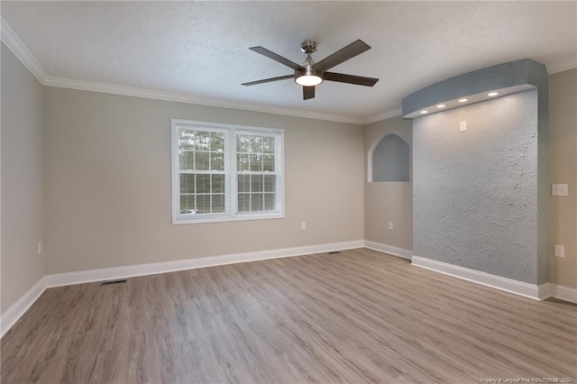 spare room featuring a textured ceiling, a ceiling fan, baseboards, and wood finished floors