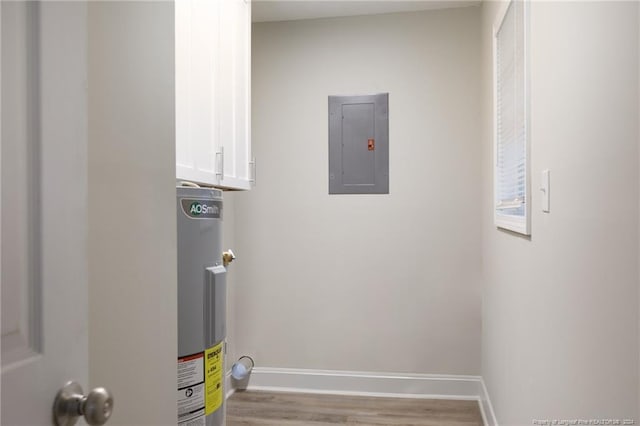 utility room with electric panel and water heater