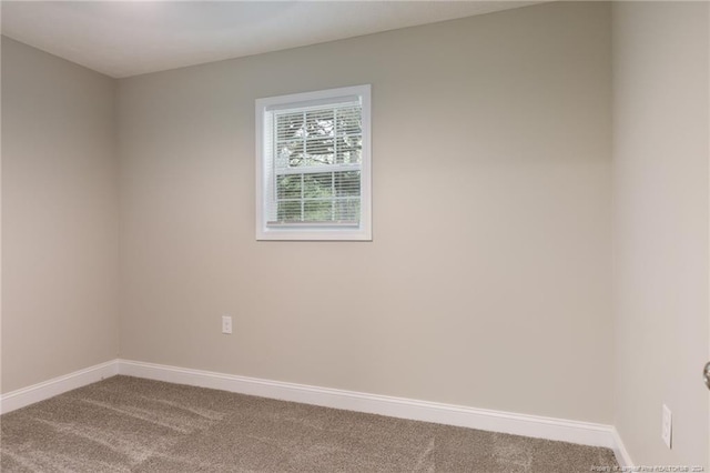 carpeted spare room featuring baseboards