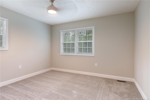 unfurnished room featuring baseboards, carpet floors, and visible vents