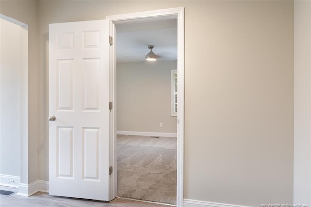 hallway with visible vents, baseboards, and carpet floors