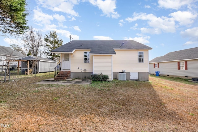 rear view of property featuring central AC unit and a lawn