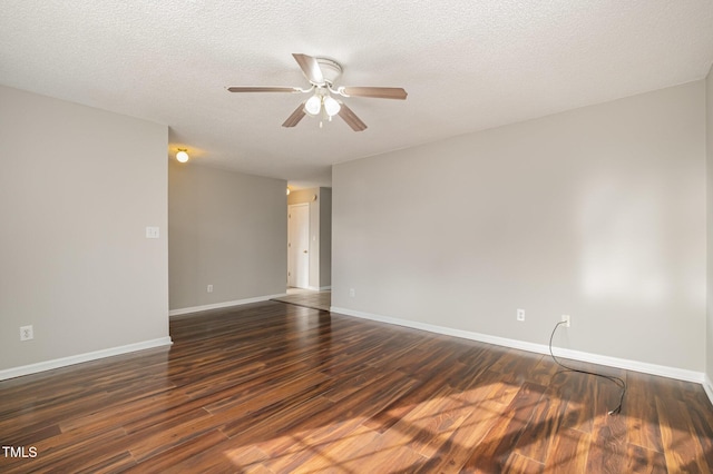 empty room with ceiling fan, dark hardwood / wood-style flooring, and a textured ceiling