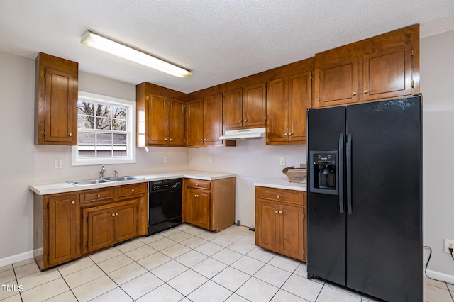 kitchen featuring sink, light tile patterned flooring, black appliances, and a textured ceiling