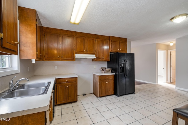 kitchen featuring light tile patterned flooring, black fridge with ice dispenser, a textured ceiling, and sink