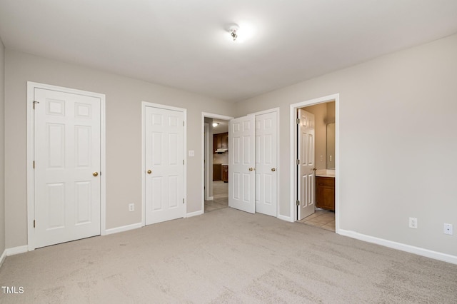 unfurnished bedroom with light colored carpet and ensuite bath