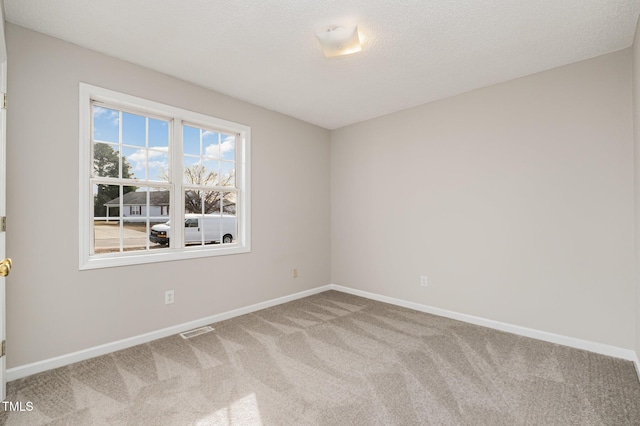 carpeted spare room featuring a textured ceiling