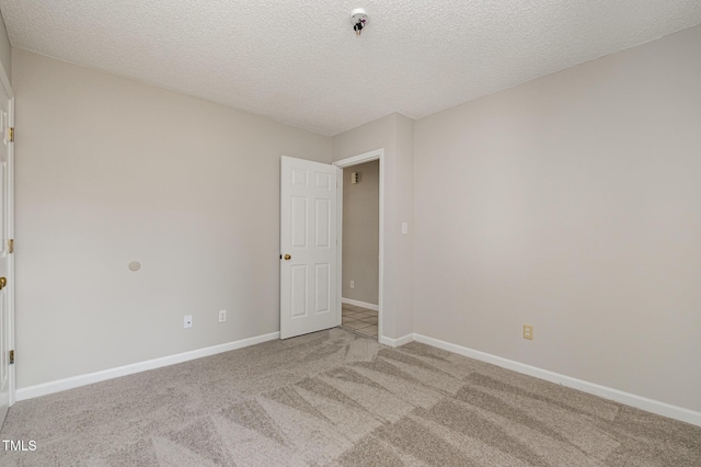 unfurnished room with light carpet and a textured ceiling